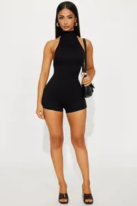 Schwarzer rückenfreier Jumpsuit mit Neckholder-Ausschnitt an Model präsentiert