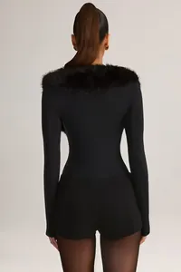Back view detail of a black slim long-sleeve jumpsuit with a plush faux fur collar