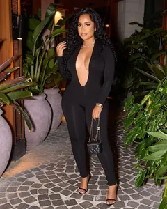 Sexy black deep V-neck long sleeve jumpsuit worn by model in a night garden setting