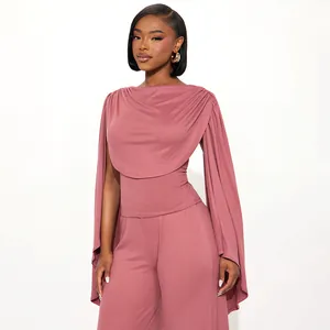 Elegante completo due pezzi rosa con top a mantella drappeggiato e pantaloni larghi