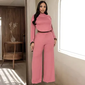 Elegante set due pezzi rosa antico con top corto a maniche lunghe e pantaloni a gamba larga.