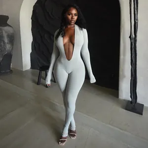 Macro view of the deep plunge V-neckline on a grey long sleeve bodycon fashion jumpsuit
