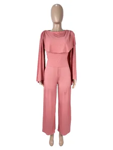 Elegante completo rosa a due pezzi da donna con maniche a mantella e pantaloni larghi.