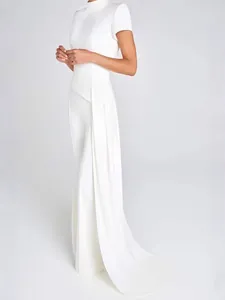 Seitenansicht eines eleganten Sets aus weißem Rollkragenoberteil und fließender Hose