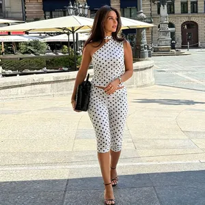 Ganzkörperansicht eines weißen Polka-Dot-Sets mit One-Shoulder-Top und passender Hose
