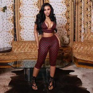 Detail view of a sexy red and black polka dot print crop top and leggings set on a model