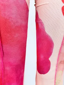 Détail macro du tissu en maille rose sexy à double couche avec motifs floraux rouges