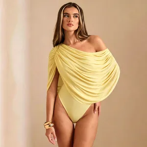 Detail view of a sexy yellow one-shoulder bodysuit with elegant draped ruched fabric.