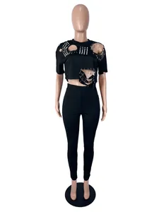 Punk stijl tweedelige set met distressed top met studs en zwarte legging op paspop
