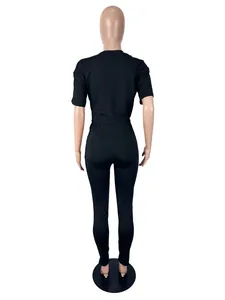Achteraanzicht van sexy zwarte tweedelige set met top met korte mouwen en legging