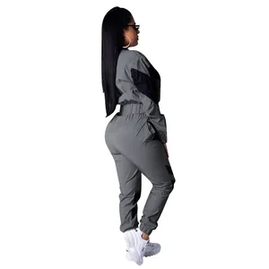 Detailed side view of grey and black color-block two-piece windbreaker tracksuit for women