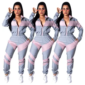 Full body view of women's two-piece color block windbreaker tracksuit in grey and pink