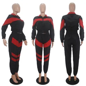 Detail view of two-piece color-block tracksuit with red and black panels