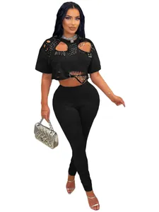 Sexy zwarte tweedelige outfit voor dames met klinknagels, veiligheidsspelden en leggings