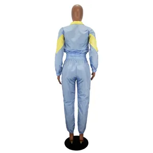 Back view of women's two-piece light blue windbreaker tracksuit with yellow patchwork