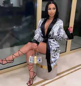 Donna glamour in vestaglia di seta sexy con stampa soldi e pochette di strass