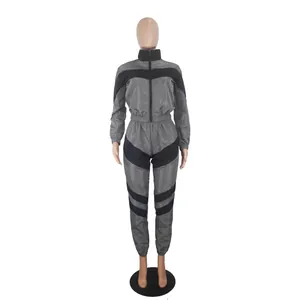 Detail view of a grey and black color-blocked long-sleeve windbreaker tracksuit set.