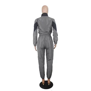 Back view of grey and black two-piece color block tracksuit with windbreaker jacket