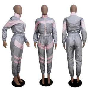 Detailed view of grey and pink color-block windbreaker tracksuit set from three angles