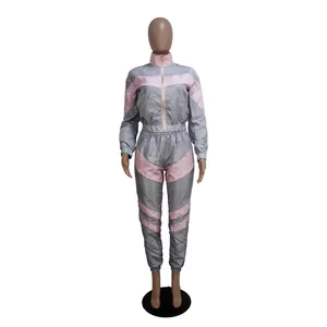Full view of women's two-piece grey and pink color-block tracksuit with zipper jacket