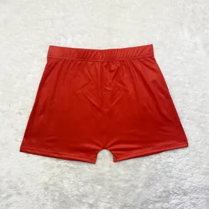 Vue détaillée du short de yoga rouge ajusté sur un fond texturé blanc moelleux.