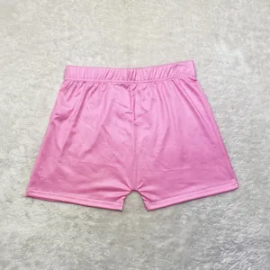 Vue à plat d'un short de yoga sexy rose moulant de couleur unie et extensible pour femmes