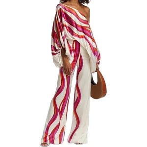 Detailed view of women's satin two-piece set with wavy fuchsia and orange patterns