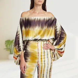 Elegant off-the-shoulder satin top and matching printed trousers two-piece set detail view.