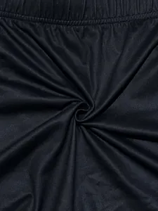 Détail de la texture d'un tissu noir élastique et respirant pour shorts de yoga