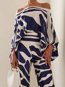 Detail of elegant blue and white satin printed off-shoulder top and trousers set