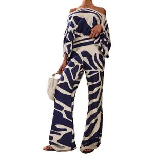 Chic off-the-shoulder satin two-piece set featuring a bold blue abstract pattern