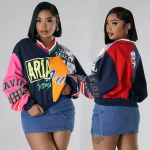 Detalle de sudadera oversize de mujer con cuello en V, patchwork y estampados de letras