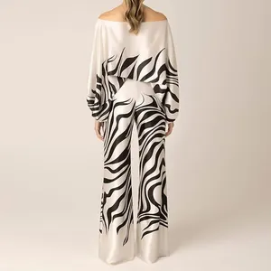 Back view of elegant two-piece satin set with black swirl print on cream fabric.