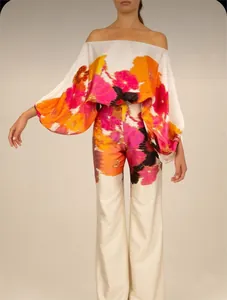 Detail of elegant floral satin two-piece set with off-shoulder top and wide-leg pants