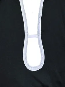 Dettaglio ravvicinato del bordo a contrasto e del design cut-out di questa tuta nera
