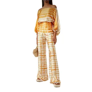 Elegant two-piece set featuring a satin off-the-shoulder top and wide-leg printed trousers