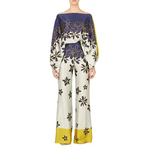 Full-body view of a stylish satin floral set featuring an off-the-shoulder top and wide trousers