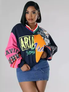 Detalle de la sudadera oversize con cuello en V, bloques de color y estampados de letras.