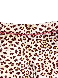 Close-up of leopard print pants waist showing red stitching and pattern detail