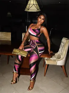 Model wearing a vibrant geometric print crop top and matching leggings with gold accessories