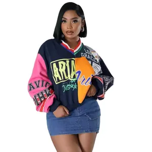 Detalle de sudadera oversize con cuello en V e impresiones gráficas vibrantes