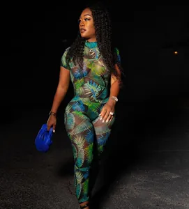 Sexy sheer mesh jumpsuit with tropical palm leaf print worn by model at night outdoors