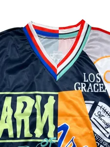 Detalle de sudadera color block con cuello en V e impresiones gráficas de letras audaces