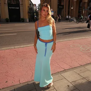 Elegante completo due pezzi celeste con canotta e gonna lunga a vita alta in strada.