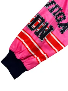Primer plano de manga de sudadera rosa con estampado de letras y puño azul acanalado