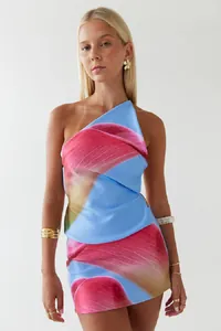 Detailaufnahme eines sexy blauen One-Shoulder-Tops und eines bedruckten Rock-Sets.