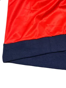 Primer plano del dobladillo de sudadera contraste rojo y azul marino con canalé.