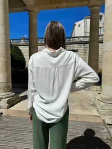 Detail of women's casual white long sleeve button-down shirt showing loose fit back view.