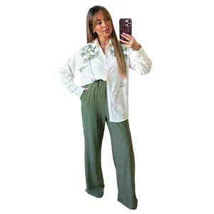 Full look of two-piece set featuring white palm embroidered shirt and green wide-leg pants.