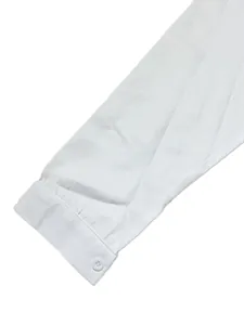 Close-up detail of a white linen-textured long sleeve shirt cuff with button closure